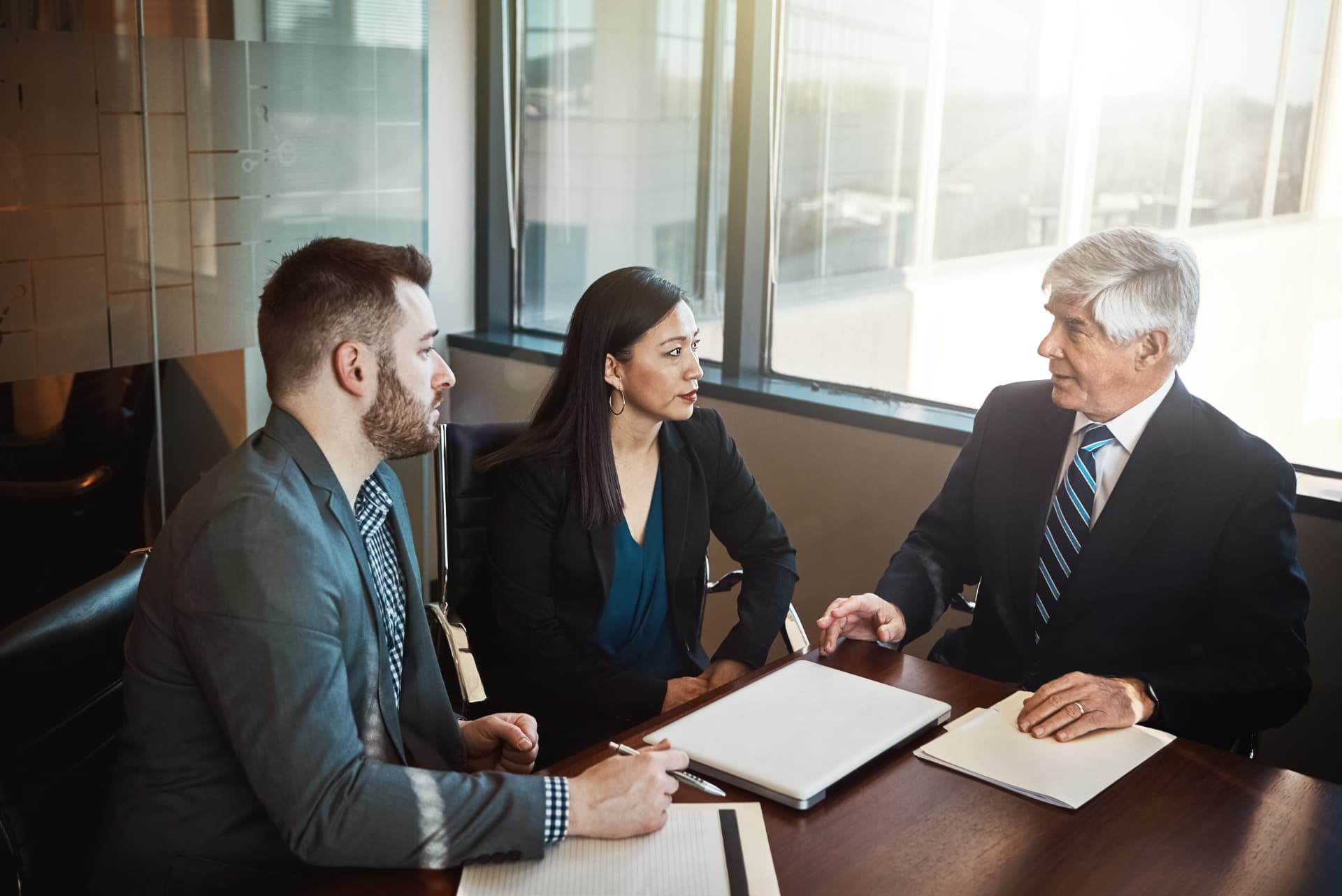 Attorney meeting with business clients over documents in a boardroom